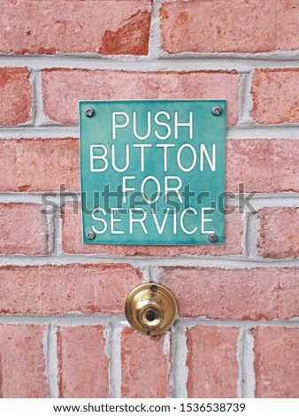 Push button for service sign on a brick wall        