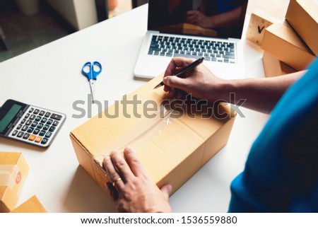 Man worker writing customer address deliver shipment online sales. Concept of small business owner.Shipment Online Sales