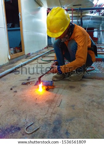 Industrial worker are cutting iron with a Welding Torch until sparks appear without safety gloves, selective focus point.