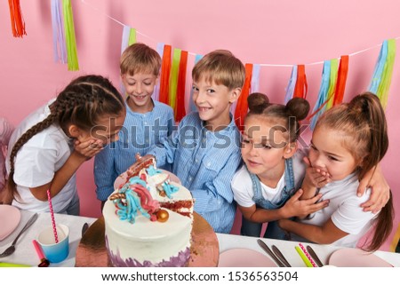 positive little girl and boys waiting for their porsion of dessert, close up photo. isolated pink background
