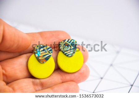 Modern bold circle stud earrings in woman hand. Handmade jewelry.