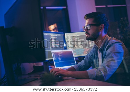 Profile side view portrait of his he nice attractive skilled focused serious guy writing script ai tech support devops creating digital solution front-end in dark room workplace station indoors Royalty-Free Stock Photo #1536573392