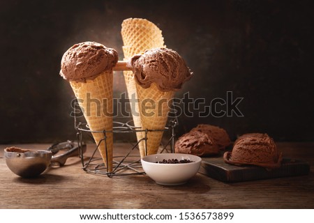chocolate ice cream in a waffle cones on a wooden table