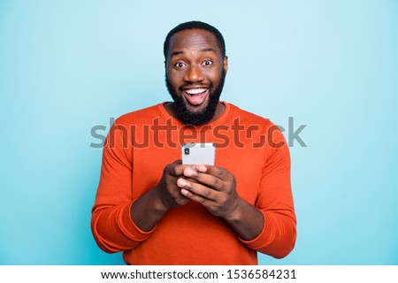 Photo of positive cheerful handsome black man smiling toothily excited about positive news known isolated vivid blue color background