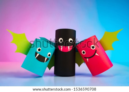 Concept - Halloween. Funny vampires. Origami. Bats. Halloween celebrations. Luchi Mice are made of paper. The bloodsuckers have fun. Concept - Halloween party. Paper vampires on a blue background