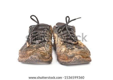 Pair of muddy shoes covered with mud