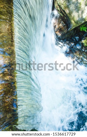 A waterfall on a small mountain river in summer