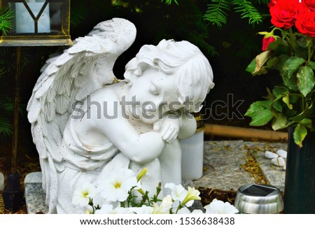 a white grave angel with closed eyes