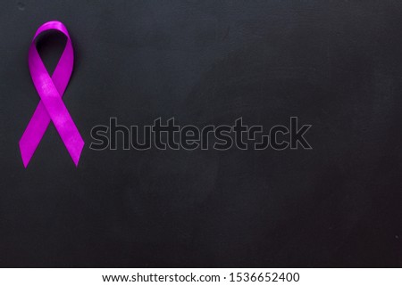 Lavender ribbon is symbol of Alzheimers disease on black background top view copy space