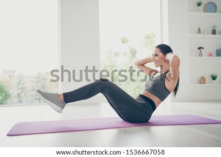 Full length body size photo of cheerful positive beautiful girlfriend enjoying doing crunches smiling toothily on floor indoors