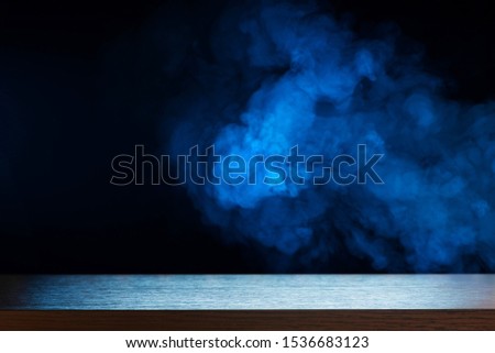Wooden tabletop on a background of blue smoke