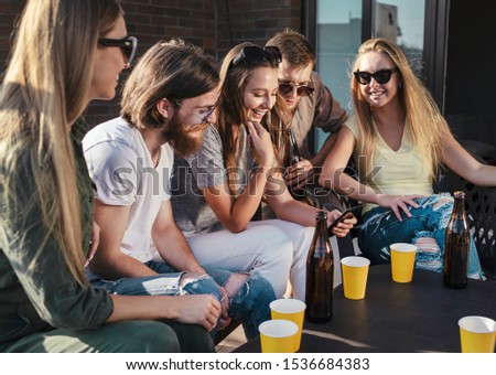 Group of friends checking photo in social media during a terrace party