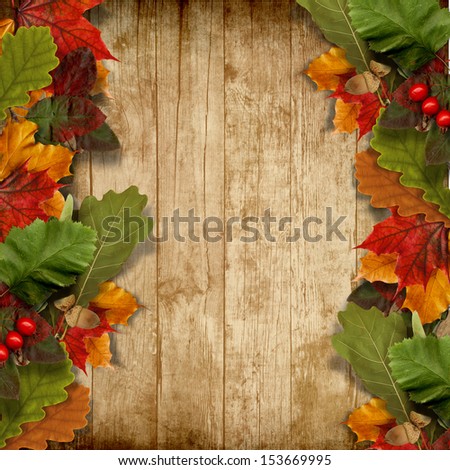 Autumn leaves over wooden background with copy space 
