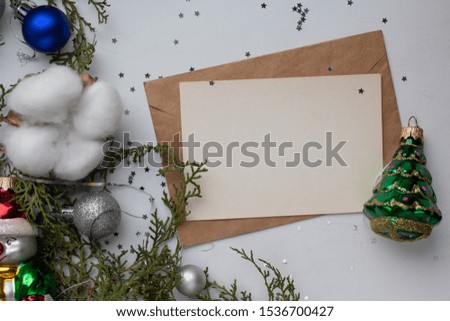 card mockup with tree balls on white table and fir branches. minimalistic Christmas background and cotton flowers. candle