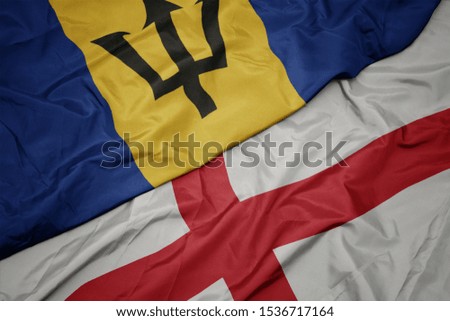 waving colorful flag of england and national flag of barbados. macro