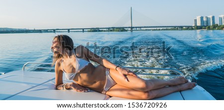 Yacht. A girl in a swimsuit sunbathes on the deck of a yacht.