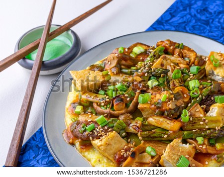 Vegan Miso polenta topped with tofu, asparagus, mushrooms and snow peas.