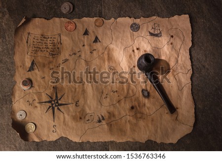 ancient map pf tresures on pirate table, old captain pipe and many different coins