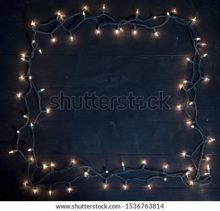 A tree lights frame over a black wooden surface great for background or writing text