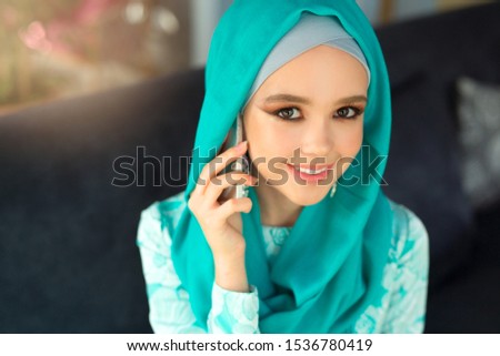 beautiful young woman in muslim dress with a phone in her hand
