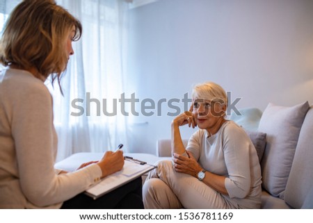 Mature female psychiatrist interviewing senior woman during therapy session. Senior woman patient and psychologist at psychotherapy session. Psychologist consulting and diagnostic examining woman Royalty-Free Stock Photo #1536781169