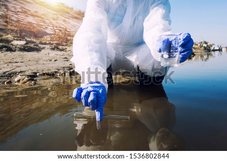 Conserve water and environment. Shot of an unrecognizable ecologist taking samples of water with test tube from city river to determine level of contamination and pollution. Royalty-Free Stock Photo #1536802844