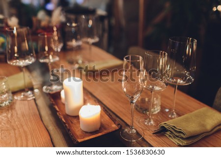 Romantic Wine Glass with Burning Candles and glasses of wine on table in darkness.