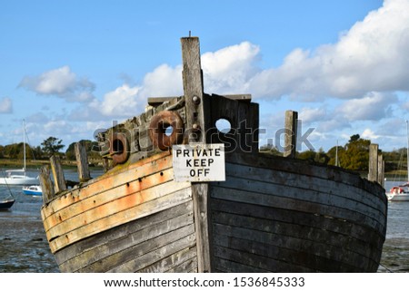 Broken old wooden boat with private keep off sign