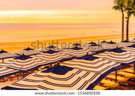 Beautiful sea ocean beach with palm tree at sunrise time for holiday vacation