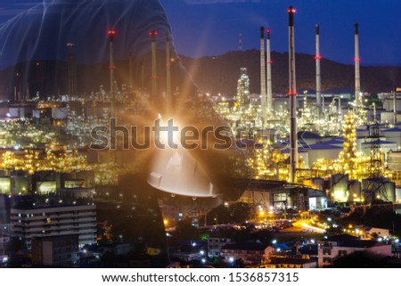 businessman Foreman working with night oil refinery industry plant and double exposure. Factory in the night as communication of energy. Smart technology 4.0 and communication
