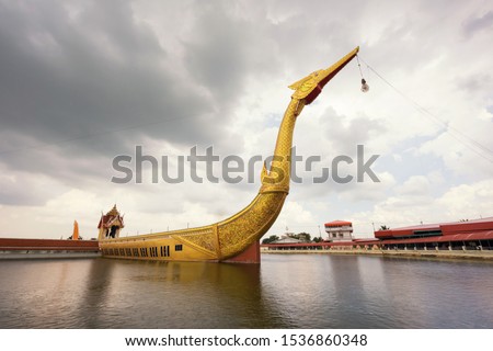 Big golden Suphan Hong boat or supannahong in large pond at Wat Sra Long-Ruea or Sra Long Rua in Kanchanaburi, Thailand. Famous travel destination for Buddhist religion.