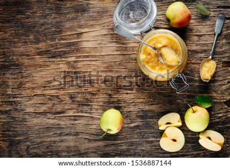 Apple sauce in jars on wooden rustic background, top view, copy space