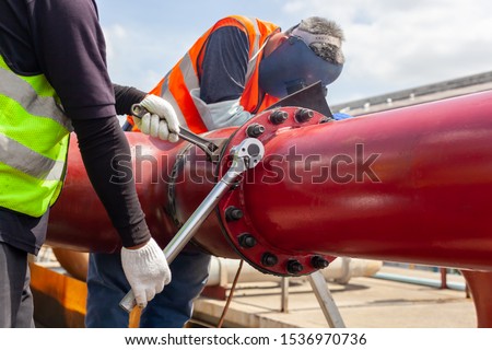 Worker install Tightening bolts & Nuts of piping Flange system. In the industrial plant. Royalty-Free Stock Photo #1536970736