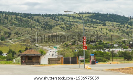 Highway traffic and mountain view in the background with a Enter sign in the foreground