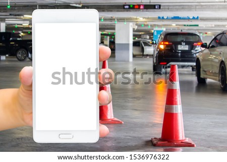 Girl use mobile phone, blur image of parking place in the building as background.