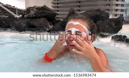 Young girl enjoying thermal bath pool.