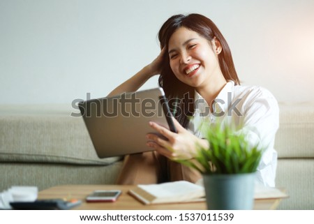 Woman relaxing on sofa in the living room enjoying sunny morning on the day Happy casual beautiful woman working on a laptop sitting in the house. 