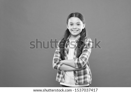 confident girl. kid long hair. small girl checkered shirt. happy child. happy childrens day. childhood memory. little girl orange background. kid fashion. smiling school girl. copy space