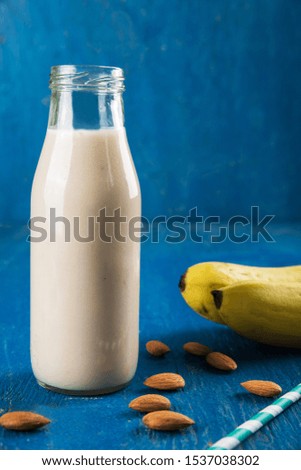 Banana Smoothie in a Bottle with Almond 
 and Banana Fruit on Table