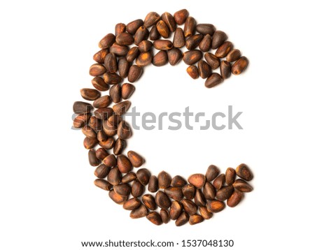 Letter made from unpeeled cedar nuts. Organic product. Ingredient for a healthy diet. New Year font. Graphic resources isolated symbol in the form of the letter C.
