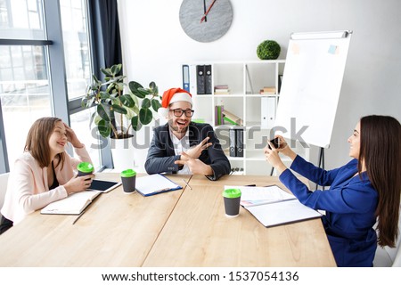 Workers in office. Cheerful attractive people celebrating new year or Christmas. Brunette taking picture of man and smile. Happy together. Holidays at work.