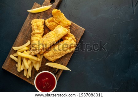  fish and chips with french fries, on a stone background with copy space for your text