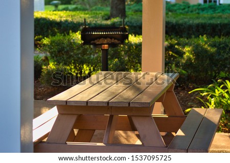 Summer Picnic table and barbeque grill in the morning sunshine. Royalty-Free Stock Photo #1537095725
