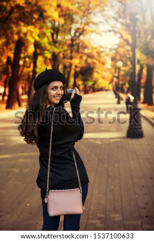 happy smiling woman in hat holding retro camera and taking picture
