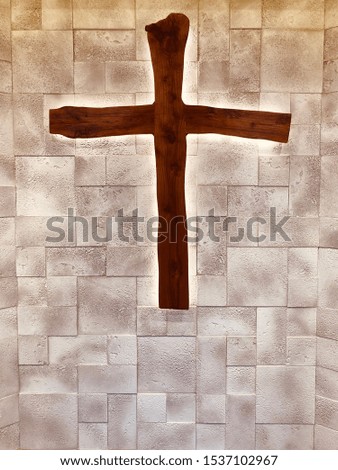 wooden cross hanging on the brick wall in the christian church forbelief  worship and pray ,concept of  spiritual sign of savior ,forgiveness and redemption from Jesus Christ in heaven