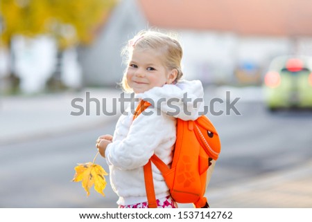 Cute little adorable toddler girl on her first day going to playschool. Healthy happy baby walking to nursery school. child with backpack going to day care on the city street, outdoors Royalty-Free Stock Photo #1537142762