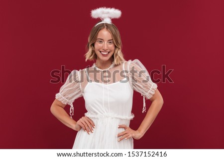 Photo of cute positive woman angel in carnival costume isolated over red wall background.