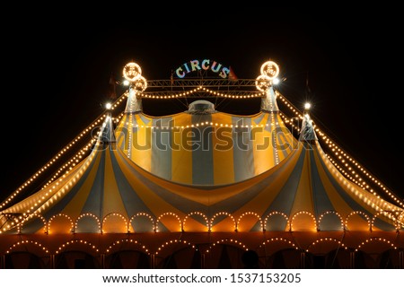 Circus tent at night with its colorful lights on Royalty-Free Stock Photo #1537153205