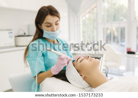 Professional female cosmetologist doing hydrafacial procedure in Cosmetology clinic. Doctor use hydra vacuum cleaner. Rejuvenation And Hydratation. Cosmetology Royalty-Free Stock Photo #1537173233