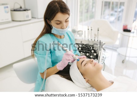 Professional female cosmetologist doing hydrafacial procedure in Cosmetology clinic. Doctor use hydra vacuum cleaner. Rejuvenation And Hydratation. Cosmetology Royalty-Free Stock Photo #1537173239